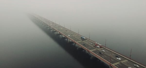 Illustration of a bridge in heavy fog with cars within stock loan market